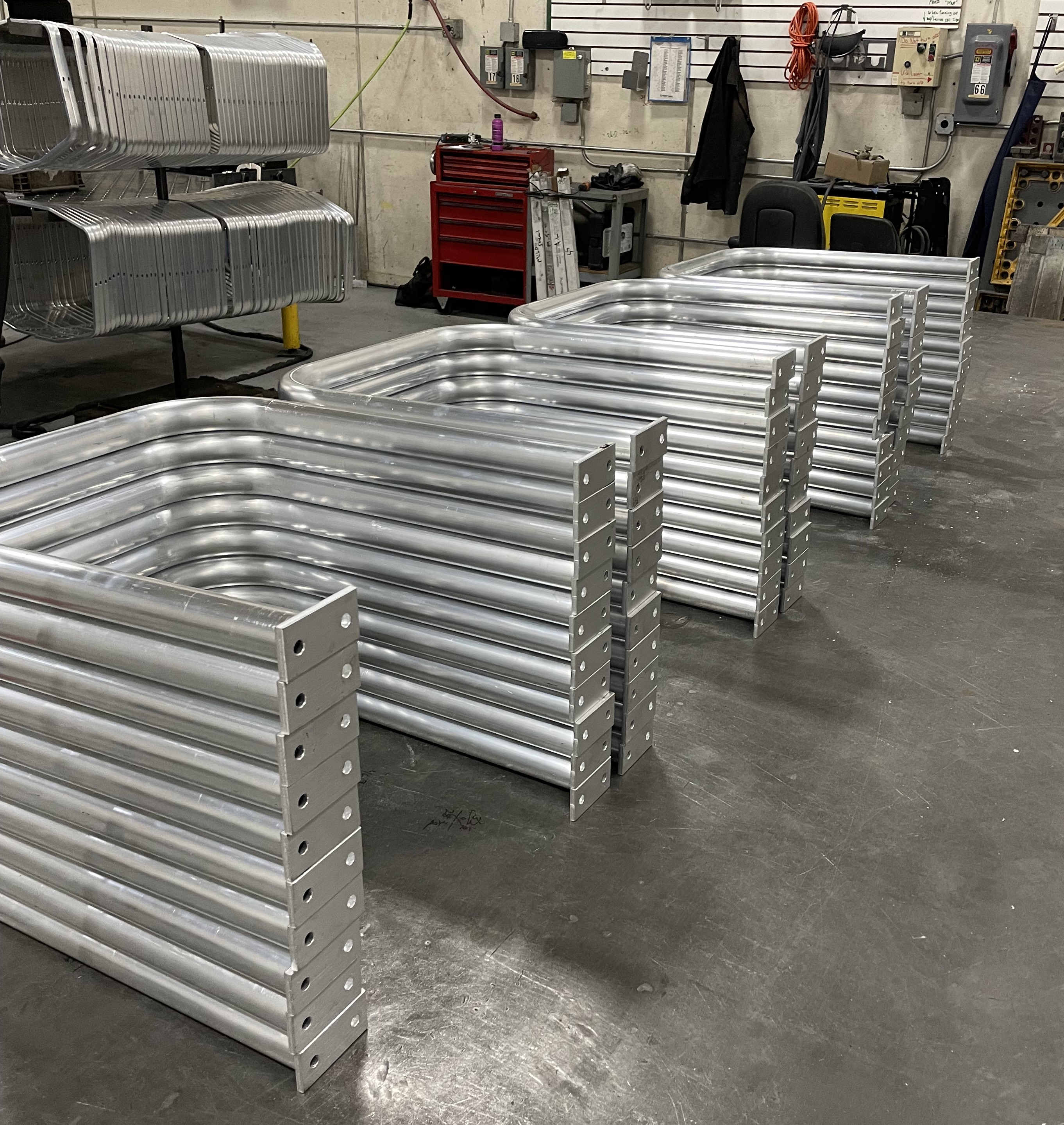 Aluminum tube formed and tabs welded on for handrails.